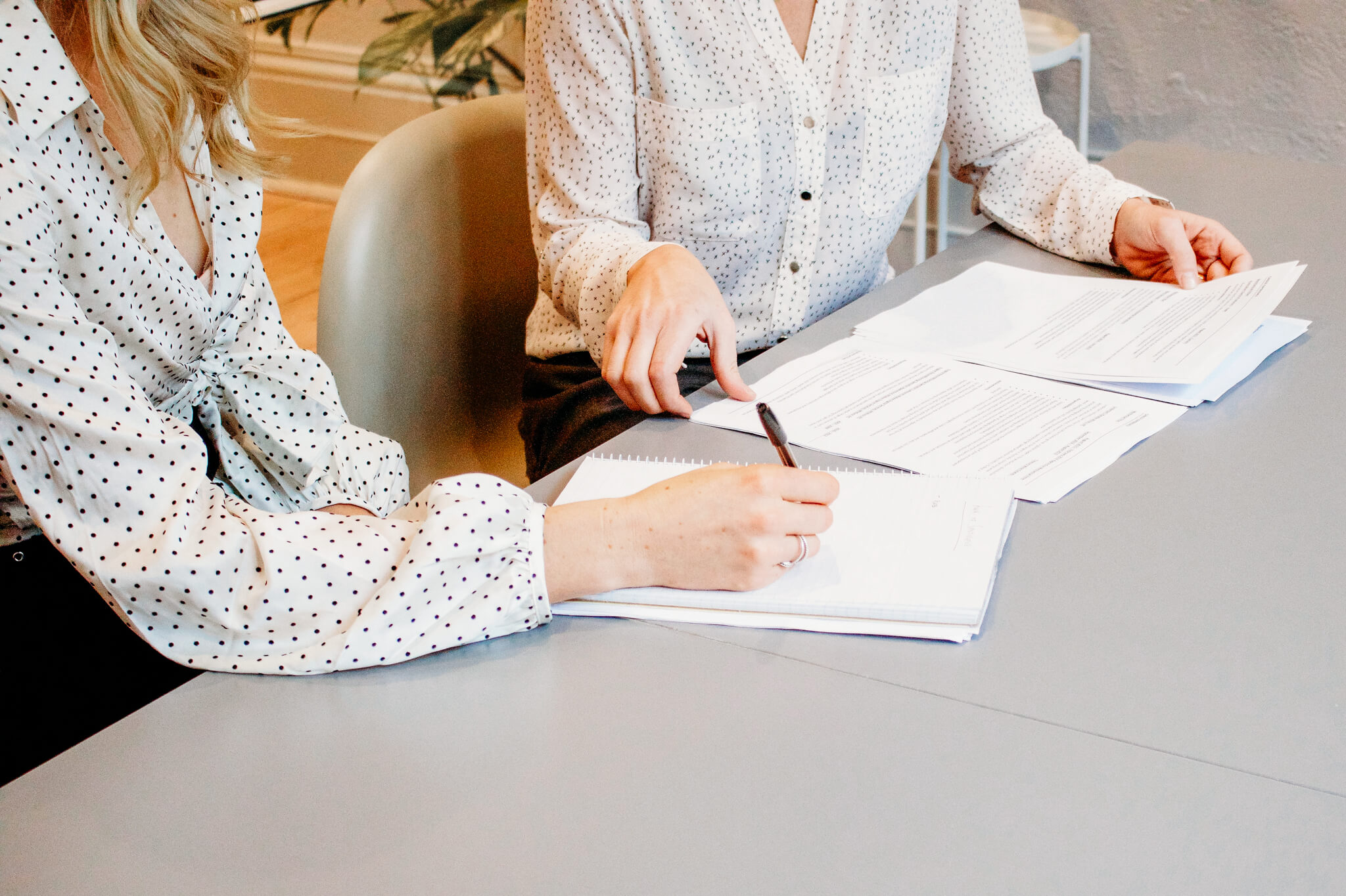 Two women in business attire review financial plan for doctor